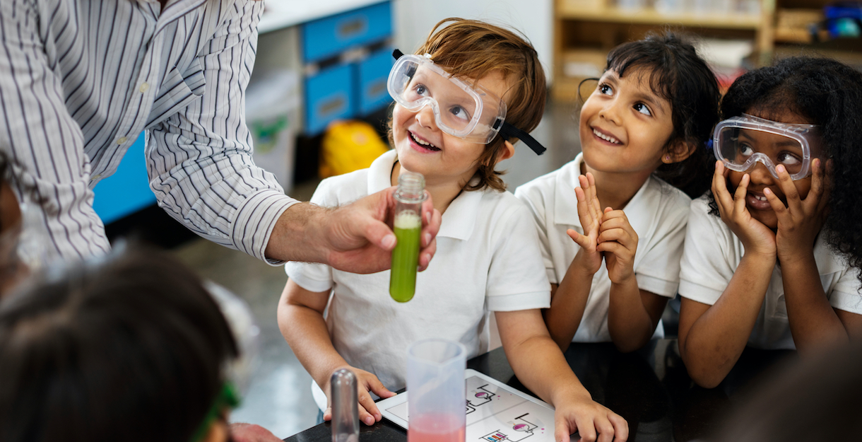 Three elementary school children are excited about a science experiment