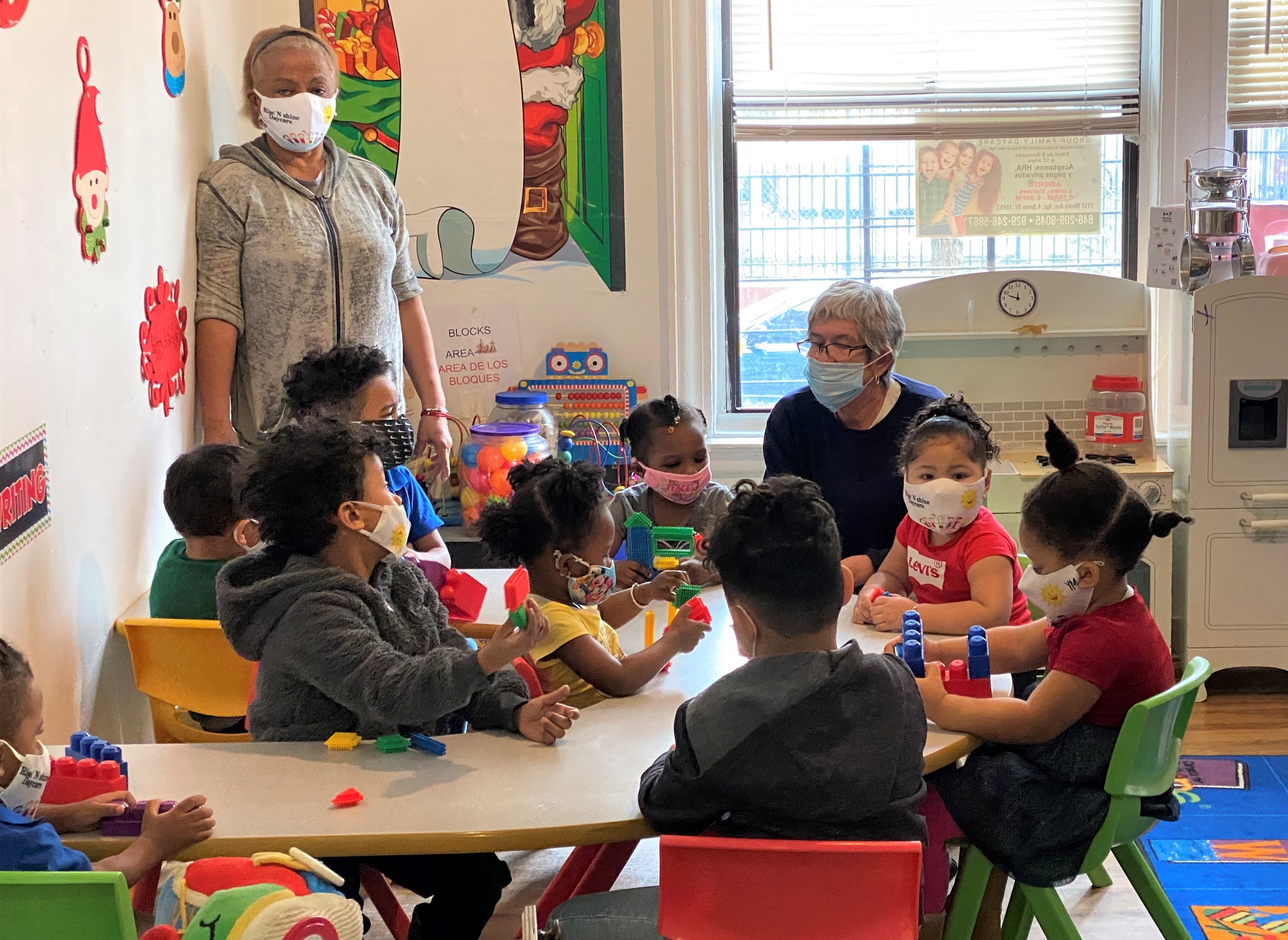 young students in a classroom for Group story time with masks on