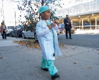 A student dressed as a doctor parading outside of school.