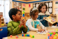 Students dressed as superheroes and princesses solve puzzles.