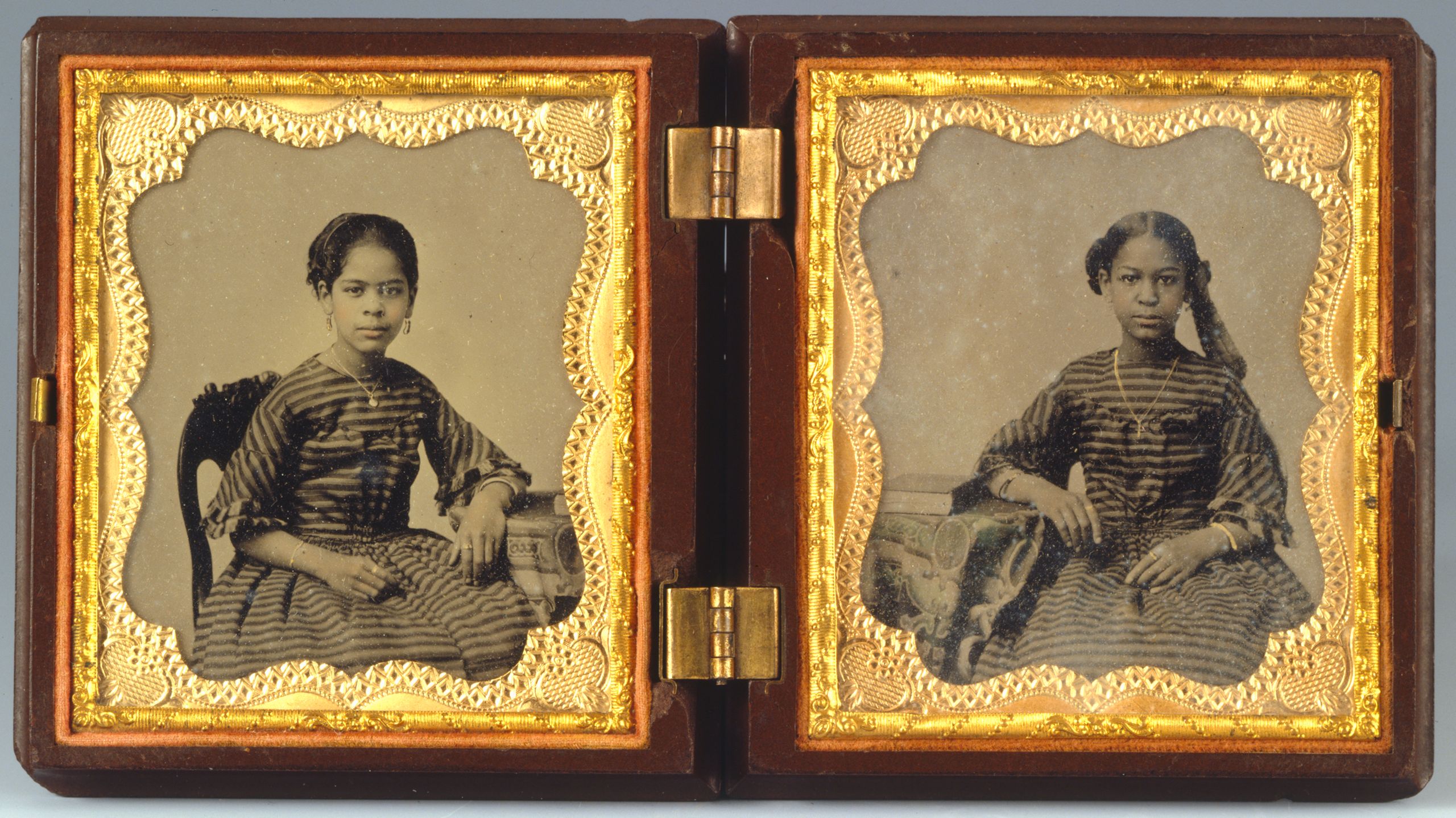Two photographs of Maritcha Lyons (left) and her younger sister Pauline (right) as children. They are wearing striped dresses with their hair up, and their photographs are inside of a frame.