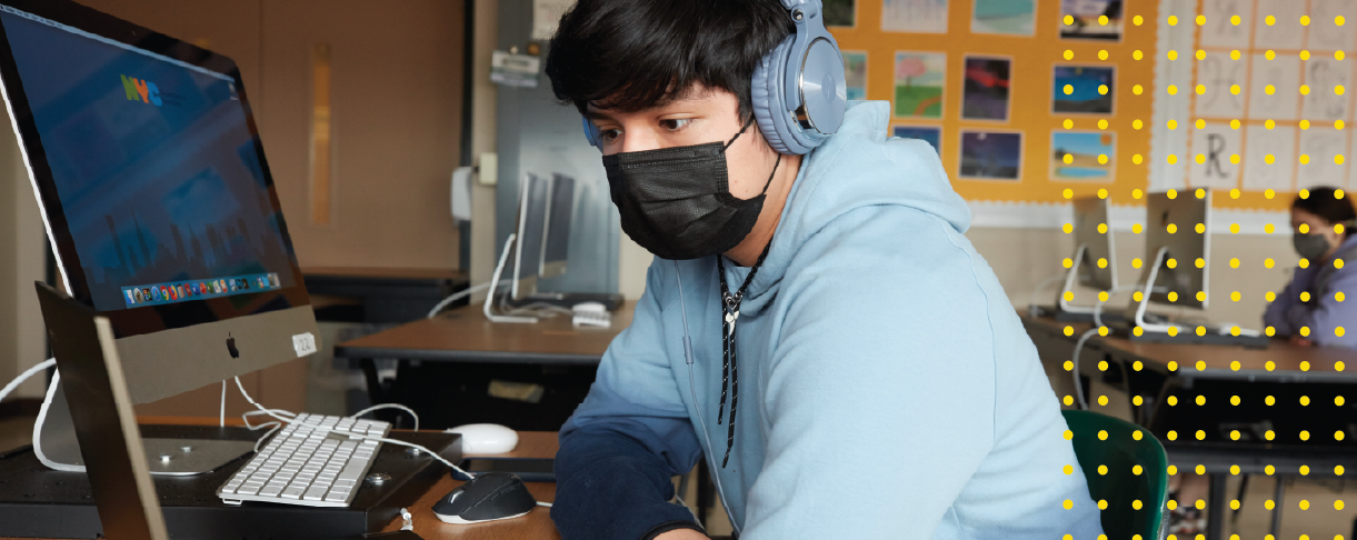 Student in class with mask on looking at a computer