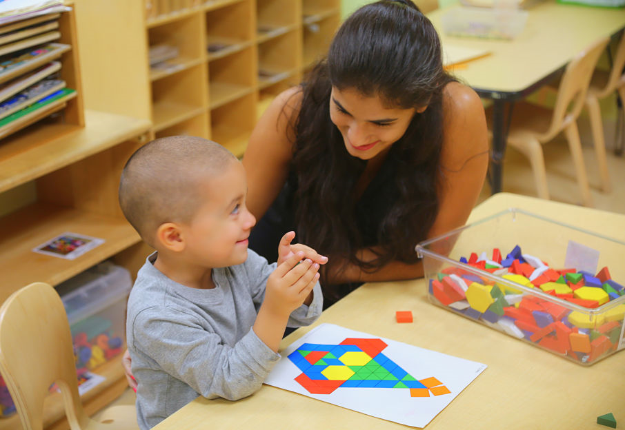 Teacher helps young child with shapes