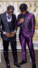 Two young men dressed in formal attire featuring dark velvets and lavenders.