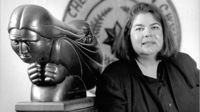 Wilma Mankiller (right) standing next to sculpture of Native American woman