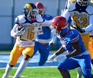 Close-up of Eagle Academy III running back, Elijah Thompson (#6), pushing through defenders during a play.