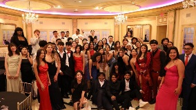 Group photo featuring students dressed in formal outfits at a prom