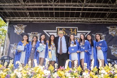 Principal John Boyle (center) standing with eight middle school graduates, four on either side of him, while on a stage.