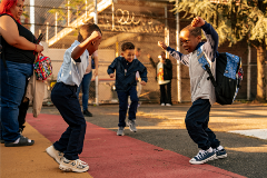 Three young students in a mini-dance battle before the start of the school day.