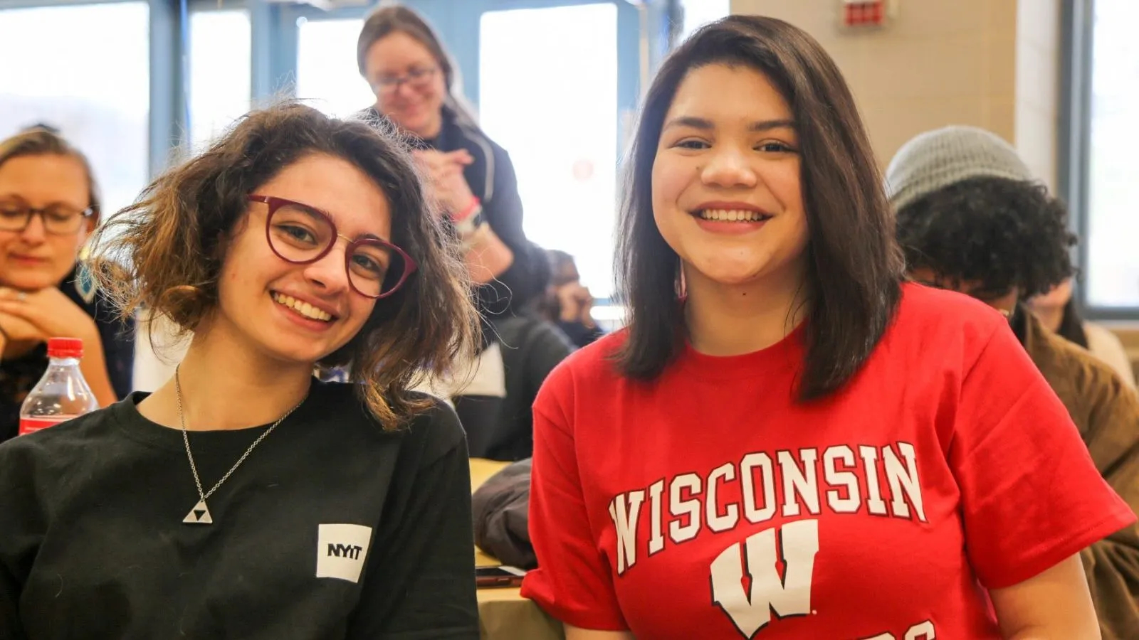 Two students wearing college shirts